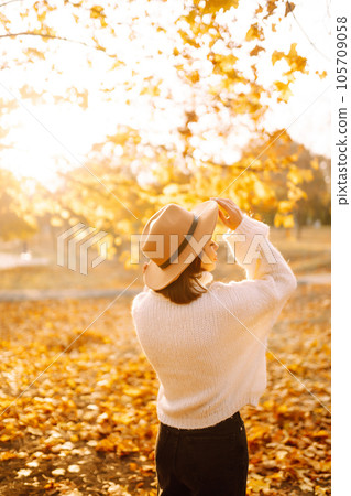 Sunny lifestyle portrait of young stylish woman walking on park, wearing cute trendy hat. Fashion concept. Sunny lifestyle portrait of young stylish woman walking on park, wearing cute trendy hat. Fashion concept. 105709058