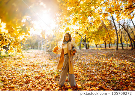 Beautiful woman taking pictures in the autumn forest. Rest, relaxation, tourism, lifestyle concept. Beautiful woman taking pictures in the autumn forest. Rest, relaxation, tourism, lifestyle concept. 105709272