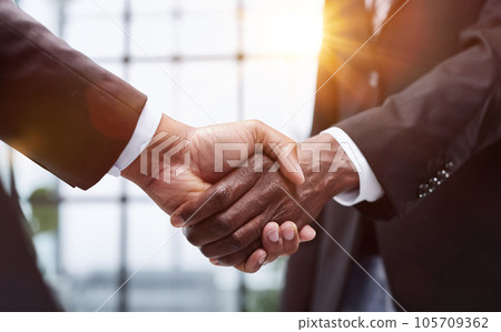 Businessmen reach out to each other to shake hands 105709362