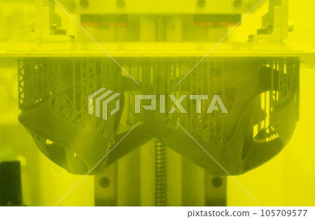 Printed models on 3D printer close-up. Objects printed on photopolymer sla 3D printer from liquid photopolymer resins on printing platform inside 3d printer. Modern progressive additive technology. 105709577