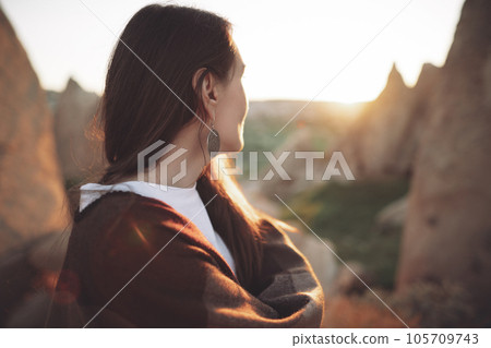 girl hiker in poncho on top of mountain at sunset. girl hiker in poncho on top of mountain at sunset. 105709743