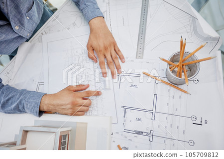 Young handsome architect engineer working on design plan 105709812