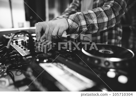 a DJ plays music on a controller at a party a DJ plays music on a controller at a party 105710304