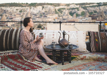 beautiful girl is relaxing with a cup of tea on the sofa in Turkish style and interior 105710327