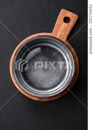 Empty round ceramic bowl on a wooden cutting board in brown color 105710452