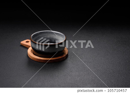 Empty round ceramic bowl on a wooden cutting board in brown color 105710457