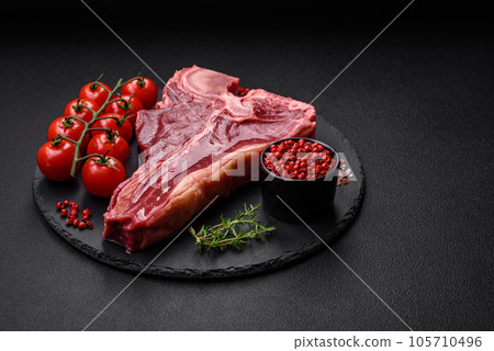 Raw fresh juicy beef t-bone steak with salt, spices and herbs 105710496