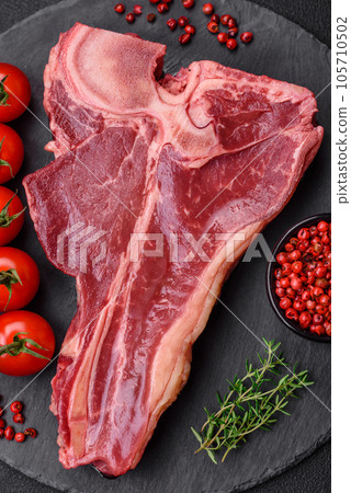Raw fresh juicy beef t-bone steak with salt, spices and herbs Raw fresh juicy beef t-bone steak with salt, spices and herbs 105710502