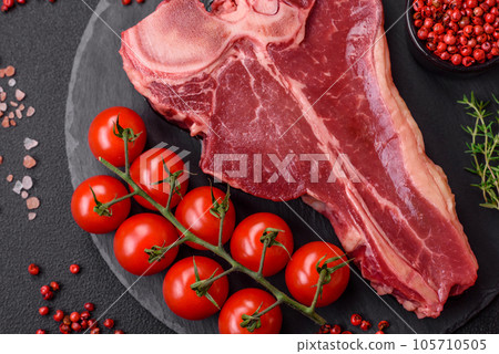 Raw fresh juicy beef t-bone steak with salt, spices and herbs 105710505