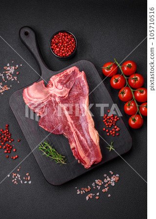 Raw fresh juicy beef t-bone steak with salt, spices and herbs 105710516