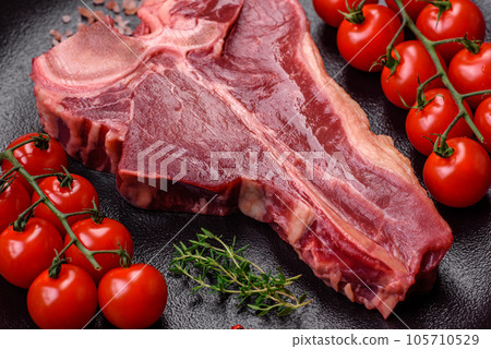 Raw fresh juicy beef t-bone steak with salt, spices and herbs 105710529
