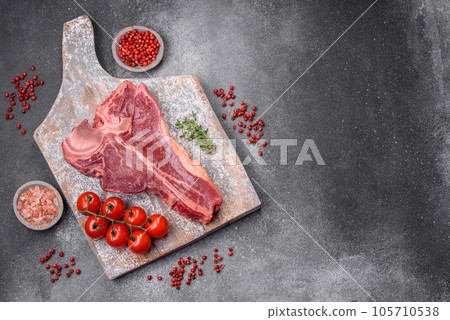 Raw fresh juicy beef t-bone steak with salt, spices and herbs Raw fresh juicy beef t-bone steak with salt, spices and herbs 105710538