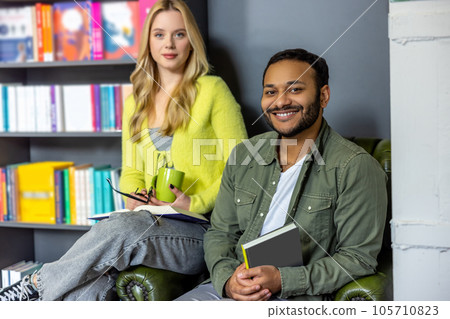 Pretty woman and young man sitting in the library 105710823