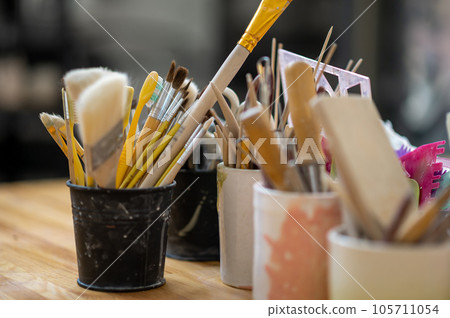 Pottery tools on wooden table in creative studio. Pottery tools on wooden table in creative studio. 105711054