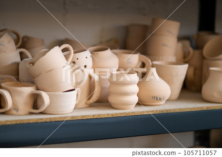 Pottery shelf in studio, creative store clay products, collection and display in workshop. Pottery shelf in studio, creative store clay products, collection and display in workshop. 105711057