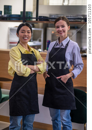 Cute female colleagues at the working place at the cafe Cute female colleagues at the working place at the cafe 105711103
