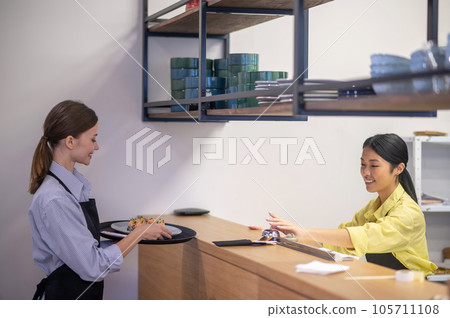 Waitress taking the order from the counter at the cafe Waitress taking the order from the counter at the cafe 105711108