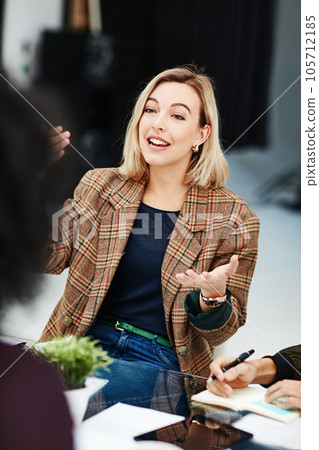 Confident, trendy and smiling businesswoman talking in meeting sharing her creative marketing ideas. Stylish team leader having a friendly staff discussion about project plans and job task management 105712185