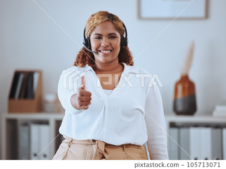 Thumbs up from happy call center agent wearing a headset and smiling in an office. Portrait of cheerful worker showing a winning hand gesture while expressing joy about good internet, positive result Thumbs up from happy call center agent wearing a headset and smiling in an office. Portrait of cheerful worker showing a winning hand gesture while expressing joy about good internet, positive result 105713071