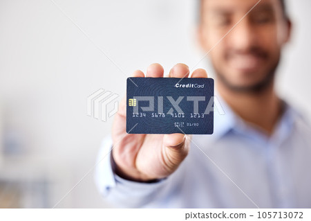 Buying, shopping and banking with a credit card or making payment, orders or bank loans. One person holding, showing and displaying a debit card to use for purchasing items, retail therapy and paying 105713072
