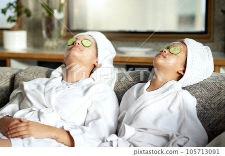 Beauty, relaxing and skincare for mother and daughter, having a spa treatment at home. Little girl and parent bonding while doing hygiene, refreshing grooming. Females with cucumber, facial mask Beauty, relaxing and skincare for mother and daughter, having a spa treatment at home. Little girl and parent bonding while doing hygiene, refreshing grooming. Females with cucumber, facial mask 105713091