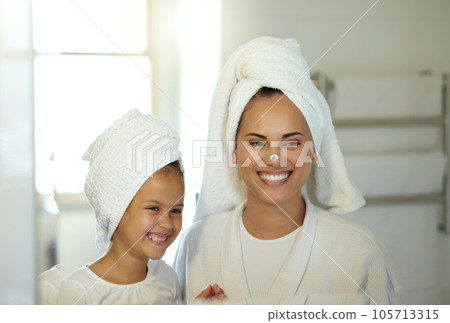 Playful mother and daughter doing a hygiene, skincare routine together in the bathroom. Mom teaching her adorable child a grooming and beauty treatment regime. Parent and little girl applying lotion Playful mother and daughter doing a hygiene, skincare routine together in the bathroom. Mom teaching her adorable child a grooming and beauty treatment regime. Parent and little girl applying lotion 105713315