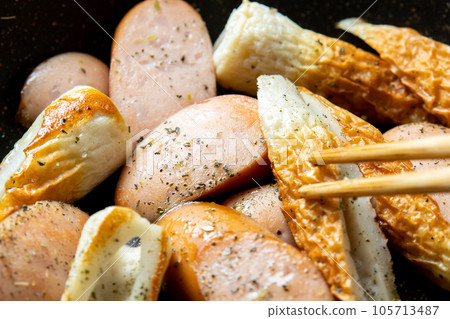 Chikuwa and frankfurter sausage stir-fried with herbs, cooking scene. 105713487
