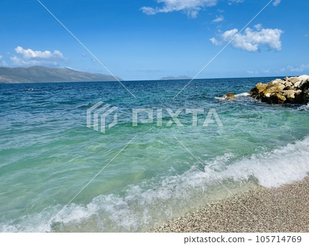 Rocky beach and crystal turquoise water of Ionian Sea in Albania. 105714769