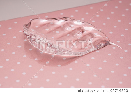 Transparent hyaluronic gel on a pink polka dots background. 105714820