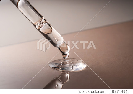 Pipette with serum, gel, oil or other cosmetic product on a beige background. 105714943