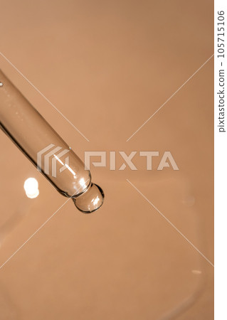A pipette of cosmetic gel on a beige background. A pipette of cosmetic gel on a beige background. 105715106