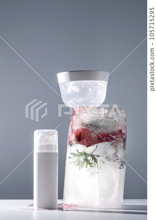 Gel and a jar of serum on a background of ice with flowers. Gel and a jar of serum on a background of ice with flowers. 105715295