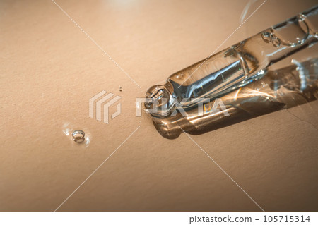 A pipette of cosmetic gel on a beige background. 105715314