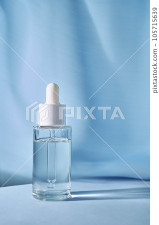 Transparent bottle of cosmetic gel on a blue background. Transparent bottle of cosmetic gel on a blue background. 105715639