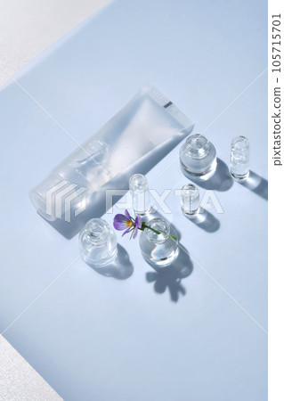 Transparent bottle of cosmetic gel on a blue background with small bottles of water. Transparent bottle of cosmetic gel on a blue background with small bottles of water. 105715701