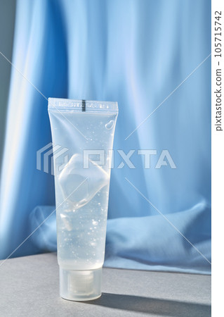 Transparent bottle of cosmetic gel on a blue background. 105715742