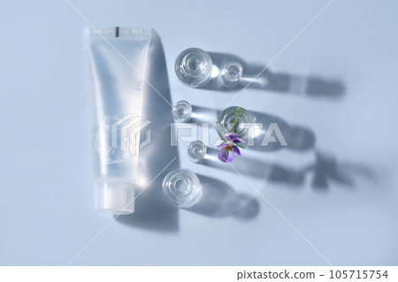 Transparent bottle of cosmetic gel on a blue background with small bottles of water. 105715754