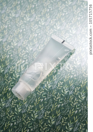 Transparent bottle of cosmetic gel on a green background. 105715756