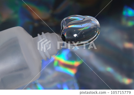 Hyaluronic gel or shower gel squeezed out of a bottle on a holographic background. 105715779