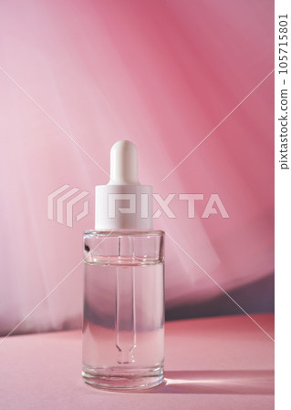 Transparent bottle of cosmetic gel on a pink background. 105715801