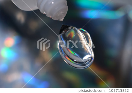 Hyaluronic gel or shower gel squeezed out of a bottle on a holographic background. Hyaluronic gel or shower gel squeezed out of a bottle on a holographic background. 105715822