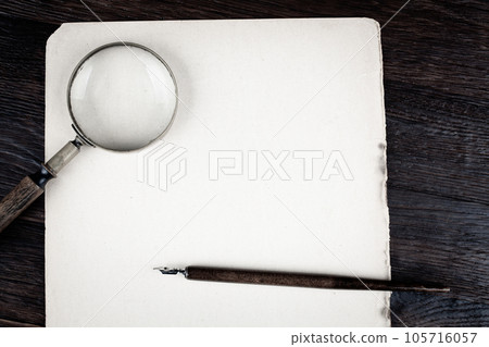 Magnifying glass with old paper and ink feather pen Magnifying glass with old paper and ink feather pen 105716057