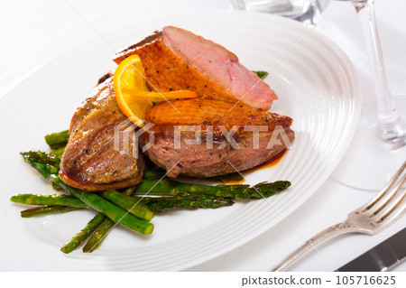 Grilled duck breast with asparagus and fried onions 105716625