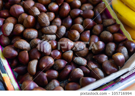 Many of chestnuts in box on market stall for sale Many of chestnuts in box on market stall for sale 105716994