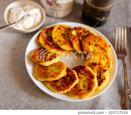 Russian syrniki, cheese pancakes with sour cream Russian syrniki, cheese pancakes with sour cream 105717016