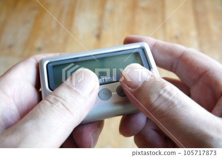 pager held in both hands pager held in both hands 105717873