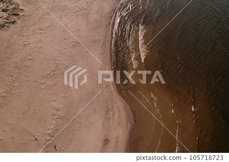 Drone aerial view of waves sea ocean coast. Beach and dunes dark calm sea waves nature landscape captured with drone. Tourism 105718723