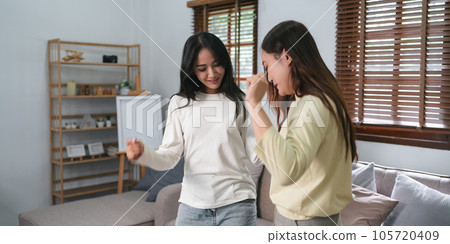 LGBT happy homosexual young lesbian couple embracing while dancing in living room at home happily LGBT happy homosexual young lesbian couple embracing while dancing in living room at home happily 105720409