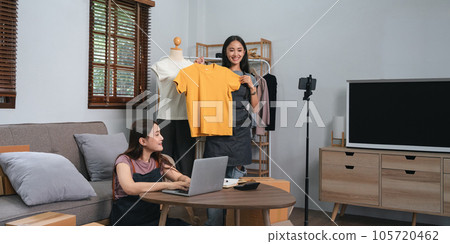 Young Asian woman two entrepreneur review product and talking camera live recording video on social network at home. Online selling, business and technology concept 105720462