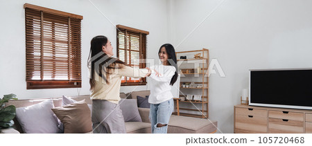 Homosexual LGBTQIA lesbian gay couple enjoy dancing together in the living room. Homosexual-LGBTQ concept. Homosexual LGBTQIA lesbian gay couple enjoy dancing together in the living room. Homosexual-LGBTQ concept. 105720468
